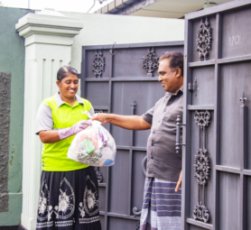 Workers collecting garbage and placing it into a waste truck