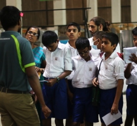Young student in school uniform standing outdoors